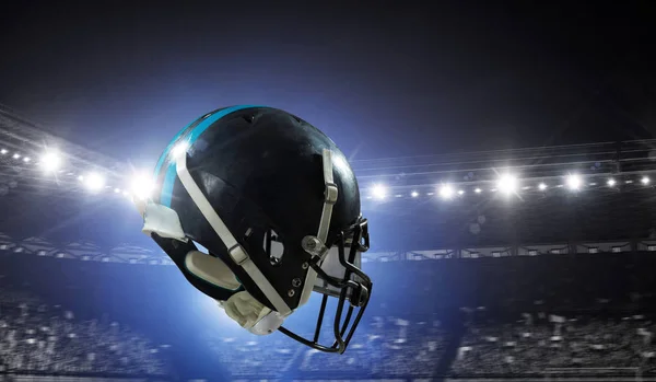ラグビー スタジアムに対するアメリカン フットボールのヘルメット ミクスト メディア — ストック写真