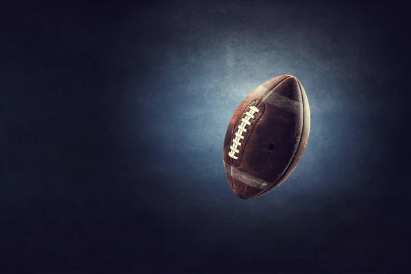橄榄球球漂浮在混凝土黑暗的背景下 混合媒体 — 图库照片
