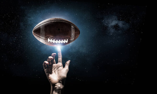 Male hand on dark background touching with finger sport ball