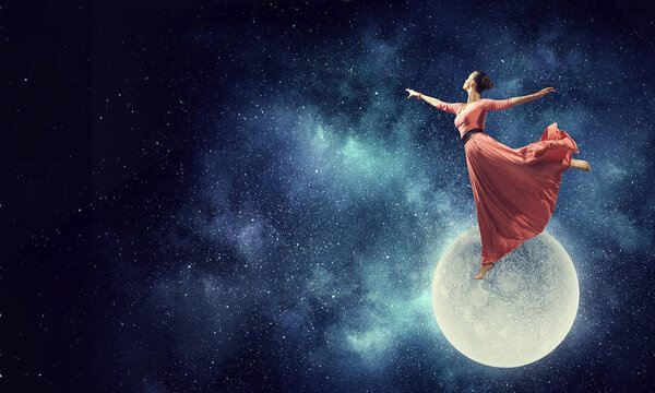 Young beautiful woman in red dress flying in air