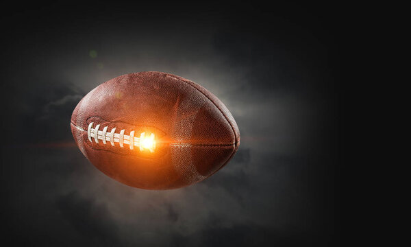 Rugby ball in lightning on a dark background. Mixed media