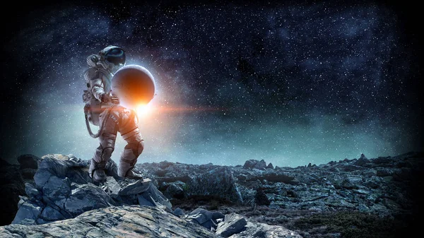 Космонавт несет большую планету. Смешанные медиа — стоковое фото