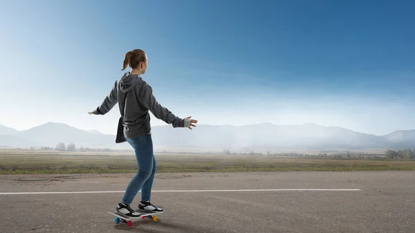 十几岁的女孩骑她的滑板。混合媒体 — 图库照片