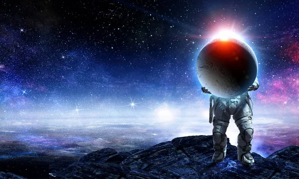 Spaceman bär stora planet. Mixed media — Stockfoto