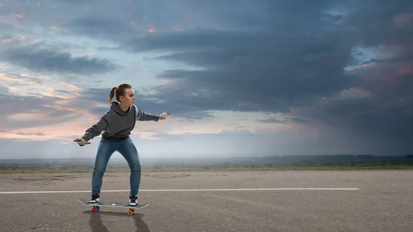 Ragazza adolescente cavalcare il suo skateboard. Mezzi misti — Foto Stock