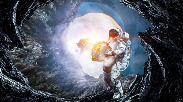 Космонавт несет большую планету. Смешанные медиа — стоковое фото