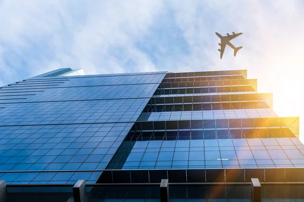 Airplane above business city — Stock Photo, Image