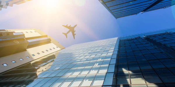 Airplane above business city — Stock Photo, Image