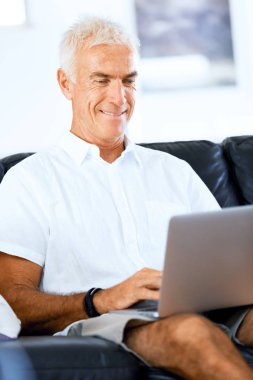 Adam evde dizüstü bilgisayarla çalışıyor.