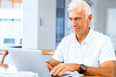 Adam evde dizüstü bilgisayarla çalışıyor.