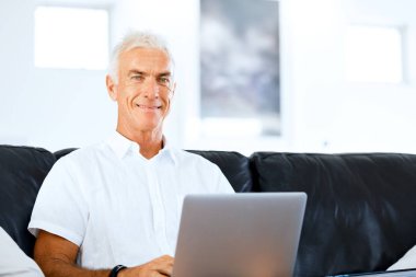 Adam evde dizüstü bilgisayarla çalışıyor.