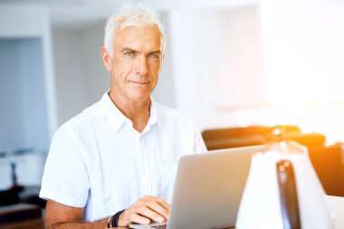 Adam evde dizüstü bilgisayarla çalışıyor.