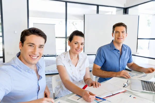 Groep van gelukkige jonge zakenmensen in een vergadering — Stockfoto