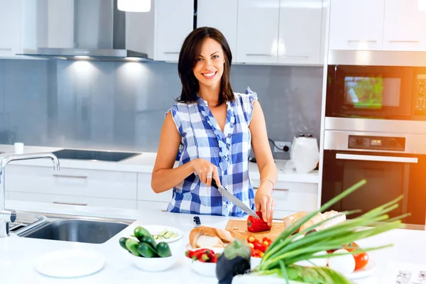 Schöne Frau steht in der Küche und lächelt — Stockfoto