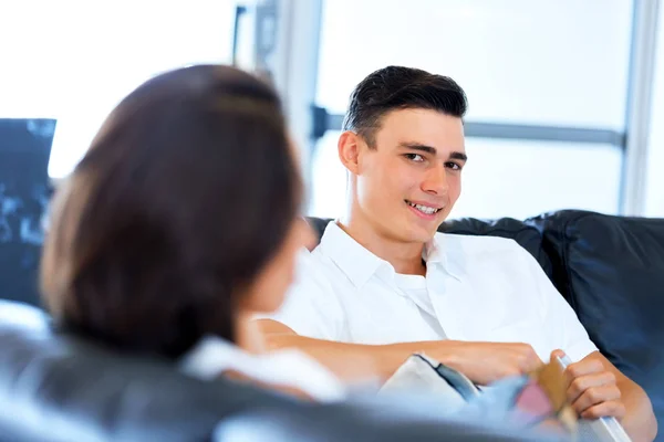 Sonriente. Pareja sentada en casa y charlando —  Fotos de Stock