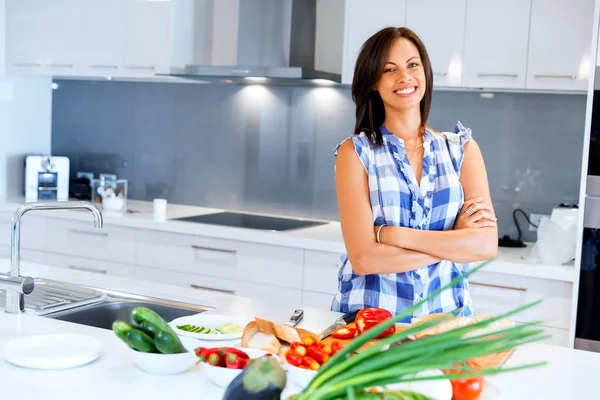 Mulher bonita de pé na cozinha e sorrindo — Fotografia de Stock