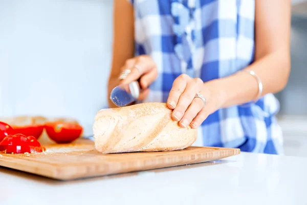 Kvinna händer skära bröd — Stockfoto