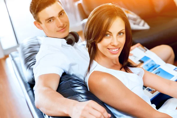 Young couple looking at camera while sitting at home — Stock Photo, Image