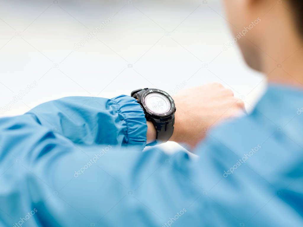 Young man in sportswear using smartwatch