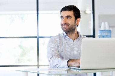 Bilgisayarda çalışan yakışıklı işadamı