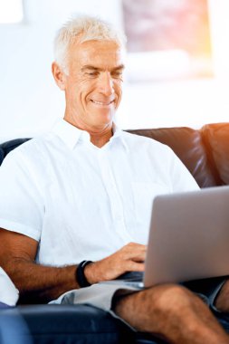 Adam evde dizüstü bilgisayarla çalışıyor.