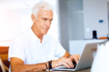 Adam evde dizüstü bilgisayarla çalışıyor.