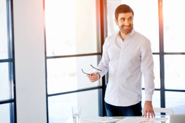 Ofiste duran genç beyaz iş adamı