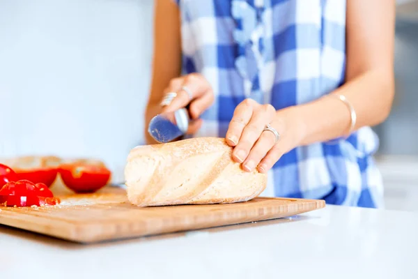 Kvinna händer skära bröd — Stockfoto