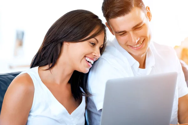 Feliz casal moderno trabalhando no laptop em casa — Fotografia de Stock