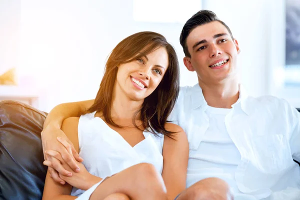 Young couple looking at camera while sitting at home — Stock Photo, Image