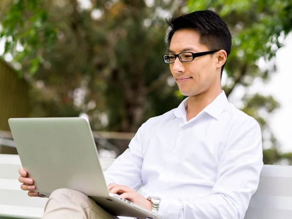 Junger Geschäftsmann sitzt mit Laptop im Freien — Stockfoto