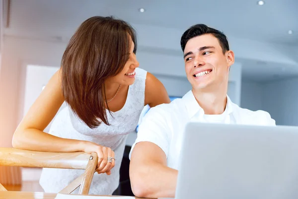 Feliz casal moderno trabalhando no laptop em casa — Fotografia de Stock