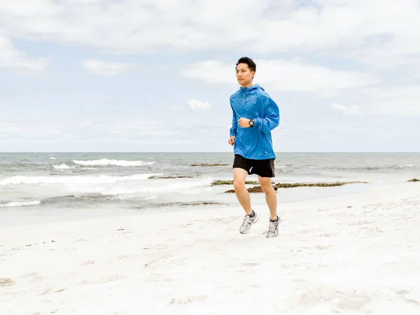 Jovem correndo ao longo do litoral — Fotografia de Stock