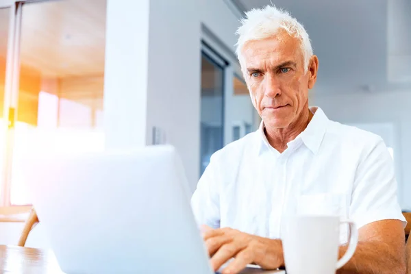 Mann arbeitet zu Hause am Laptop — Stockfoto