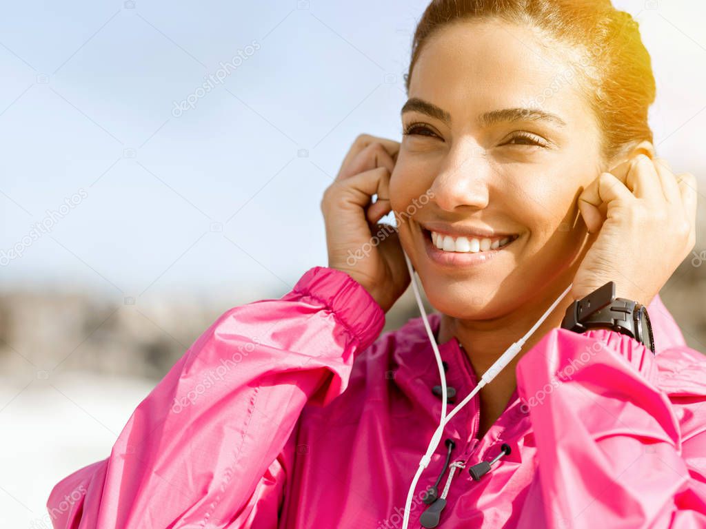 Sporty woman with earphones on the sea coast