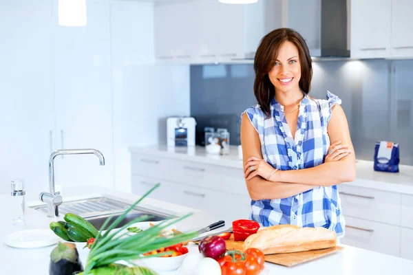 Mulher bonita de pé na cozinha e sorrindo — Fotografia de Stock