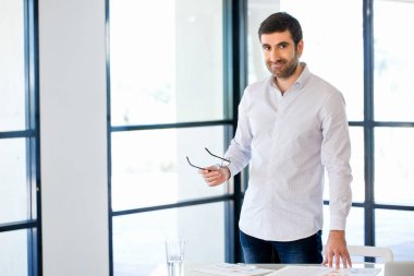 Ofiste duran genç beyaz iş adamı