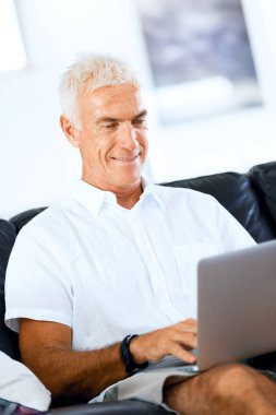 Adam evde dizüstü bilgisayarla çalışıyor.