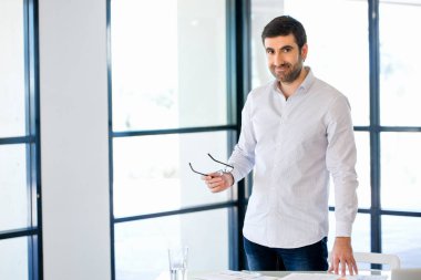 Ofiste duran genç beyaz iş adamı