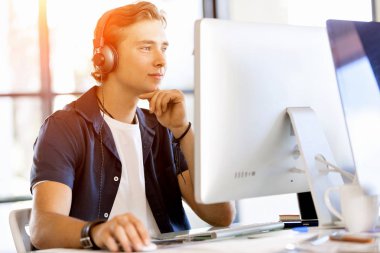 Kulaklıklar ile ofiste genç adam