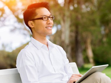 Bankta oturan ve Not Defteri'nde yazma çekici düşünceli işadamı