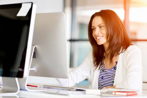 Porträt einer Geschäftsfrau, die im Büro am Computer arbeitet — Stockfoto