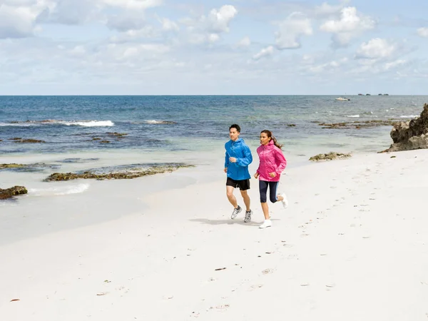 Junges Paar rennt am Meer entlang — Stockfoto