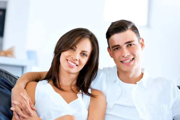 Young couple looking at camera while sitting at home — Stock Photo, Image