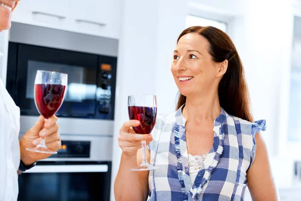 Starší žena s uvnitř drží sklenku vína — Stock fotografie