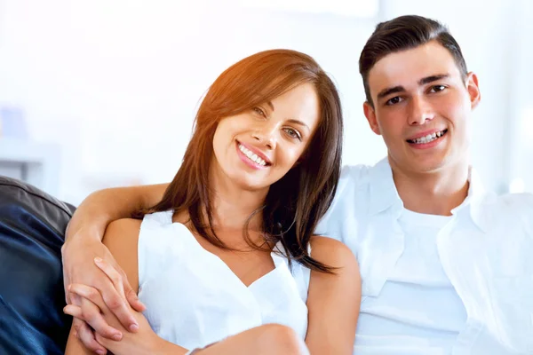 Young couple looking at camera while sitting at home — Stock Photo, Image