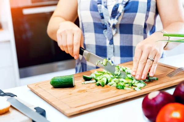 Manos femeninas cortando pepinos — Foto de Stock