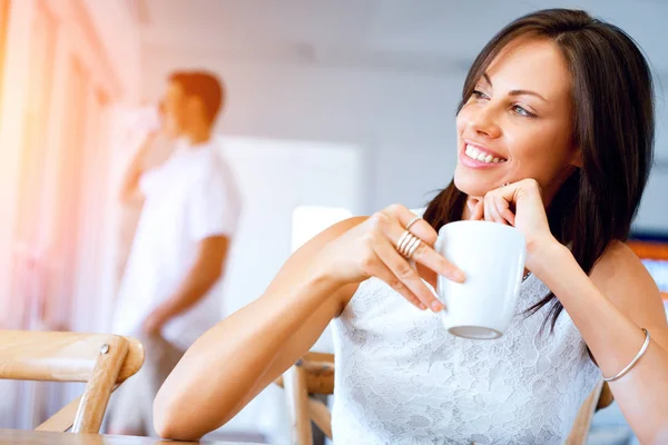 Boldog fiatal nő egy csésze tea vagy kávé — Stock Fotó