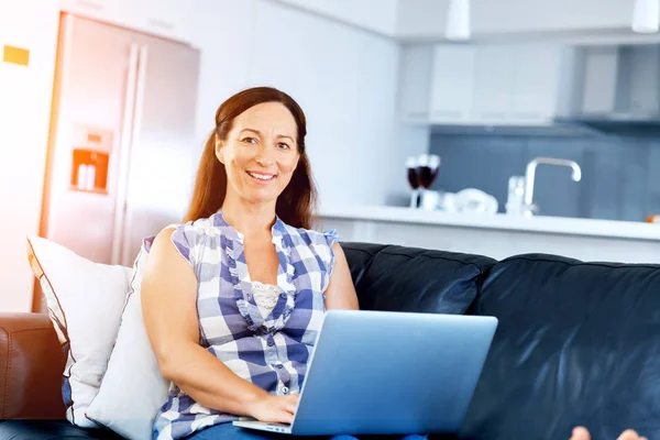 Rijpe mooie vrouw die op haar laptop werkt — Stockfoto