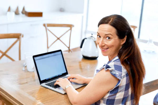 Reife schöne Frau arbeitet auf ihrem Laptop — Stockfoto